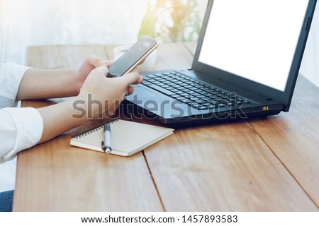 Asian woman using smartphne and lapto winking online 