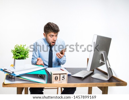 The young man getting awful, shocking message. Can't believe his eyes, loses his balance in shock, getting upset and angry. Concept of office worker's troubles, business, information problems.