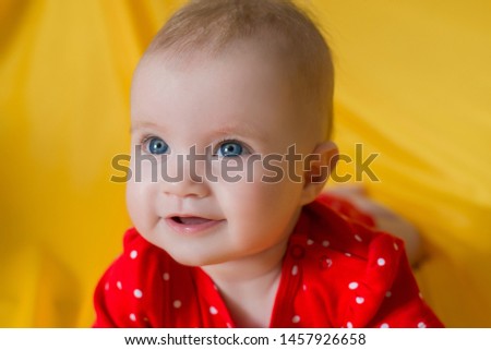 baby, portrait of a little girl with blue eyes closeup, yellow background, red clothes