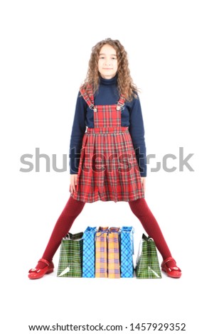 Child with a packaging checkered texture isolated on white background. Girl likes shopping on sale season. High resolution photo. 