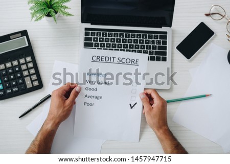 top view of young adult man holding credit score 