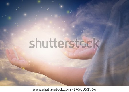 Glittering light and shines through hands of women who raise their hands to pray for God's blessings and sunset background mind sanctification concepts and pure spirit and spirituality forever