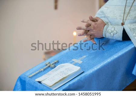 Hands of the priest on the background of the church