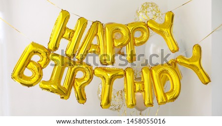 Golden HAPPY BIRTHDAY words made of inflatable balloons on white background