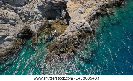 Aerial drone photo of 2 men practising sport canoe in Mediterranean rocky seascape with deep blue sea