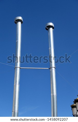 Large steel chimneys in the blue sky.