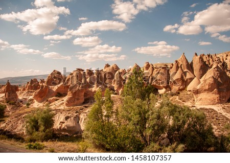 Cappadocia hotels carved from stone rock, cave style, Town of Uchisar at the sunrise. Impressive fungous forms of sandstone in the canyon near Cavusin village, Cappadocia, Nevsehir Province, Anatolia.