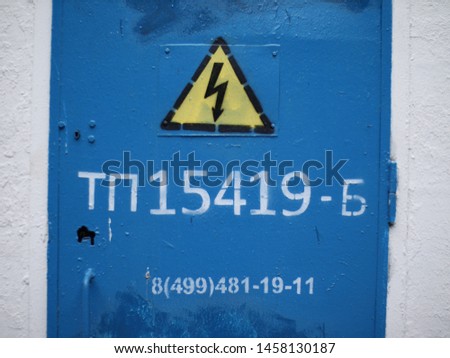 caution high voltage. pictures on a switchboard. the blue background and the sign of the voltage
