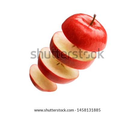 Ripe delicious apple cut in slices isolated floating on white background stock photo