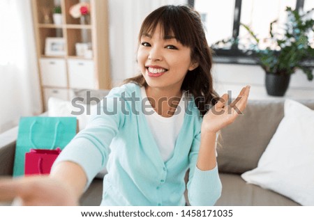 blogging, videoblog and technology concept - asian woman or blogger recording video blog or taking selfie and waving hand at home
