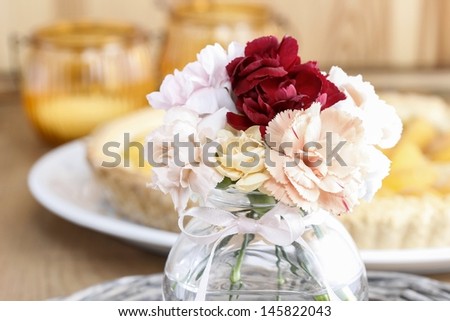 Bouquet of stunning colorful carnation flowers in transparent glass vase