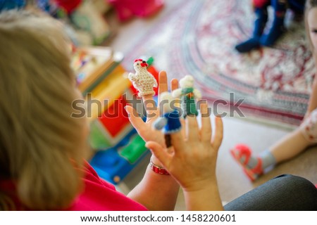 Russia, Moscow, a kindergarten teacher plays with children in a fairy tale, in his arms is a puppet theater, staging a chicken-ryaba tale Royalty-Free Stock Photo #1458220601
