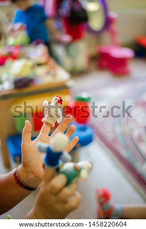 Russia, Moscow, a kindergarten teacher plays with children in a fairy tale, in his arms is a puppet theater, staging a chicken-ryaba tale Royalty-Free Stock Photo #1458220604