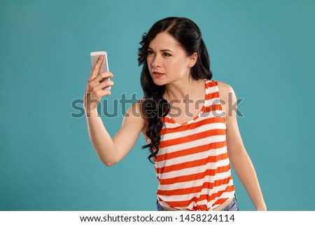 Studio photo of a gorgeous girl teenager posing over a blue background.