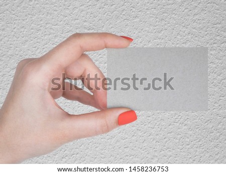 A woman holding a silvery business card