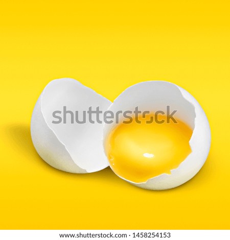 Egg minimal food concept. Broken fresh egg shell close-up with yolk on pastel yellow and orange background. Food creative