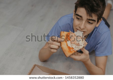 young man eating pizza at home, fast food