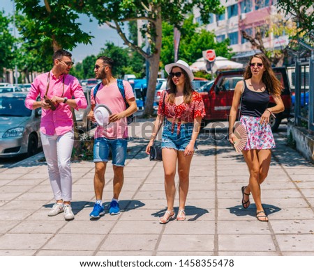 Four tourist's (explorers) taking a walk at a Mediterranean city on a beautiful sunny day in the summer