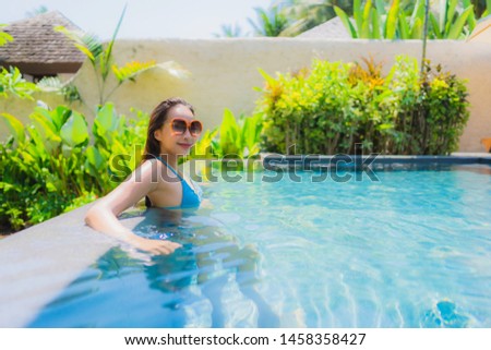 Portrait beautiful young asian woman smile happy relax and leisure in the swimming pool hotel resort for travel and vacation concept