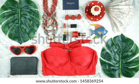 Summer vacation concept flatlay with red feminine accessories on white marble background.