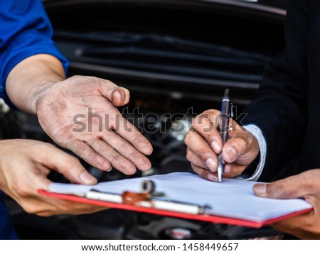 garage worker concept.closeup businessman signing on paper and worker hand 