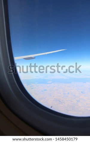 Blue sky and white clouds seen through the plane window