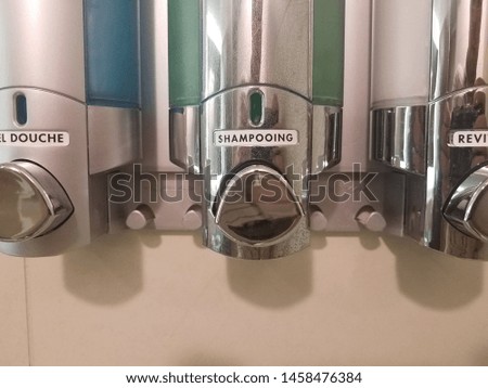 shower gel, shampoo, and conditioner in dispensers in French