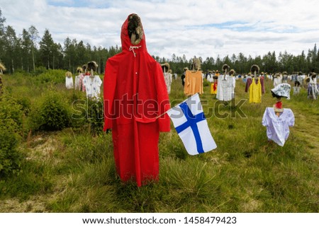 View to the group of objects that looks like people in the field. Finland. Silent People.
