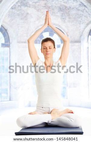 Woman meditating and doing yoga against white background