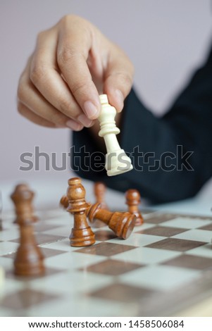 Close up shot hand of business woman playing the chess board to win by killing the king of opponent metaphor business competition winner and loser select focus shallow depth of field