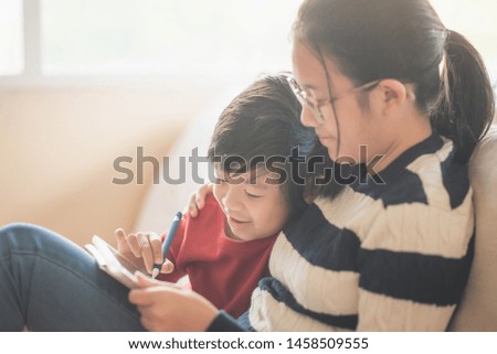 Asian children drawing picture with digital pen on tablet pc computer