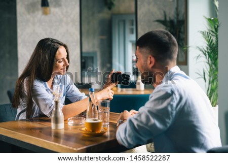 young couple in cafe bar drinking coffee and using smartphone
