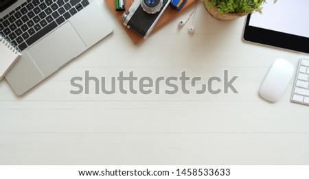 Professional photographer's desk with laptop computer, office supplies and copy space with white background  