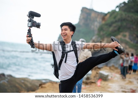 Vlogger holds and smile with his camera Royalty-Free Stock Photo #1458536399