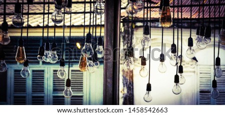 Dark Blurred background of Beautiful retro Edison lighting bulb decor at cafe restaurant on vintage style through glass window room, Interior concept idea & design for banner, wallpaper, backdrop