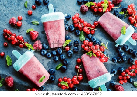 top view of delicious sweet ice lollies and fresh ripe berries on grey surface