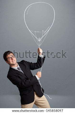 Attractive young man holding balloon drawing