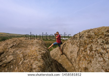 The photographer takes pictures of nature, standing on top of a cliff