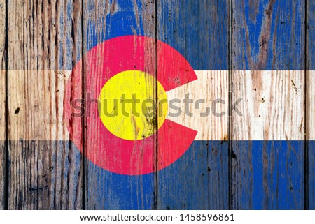 Colorado US state national flag on a gray wooden boards background on the day of independence in different colors of blue red and yellow. Political and religious disputes, customs and delivery.
