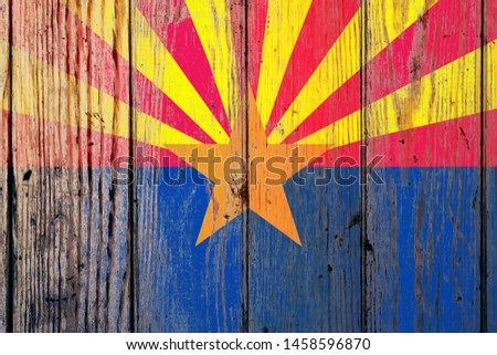 Arizona US state national flag on a gray wooden boards background on the day of independence in different colors of blue red and yellow. Political and religious disputes, customs and delivery.
