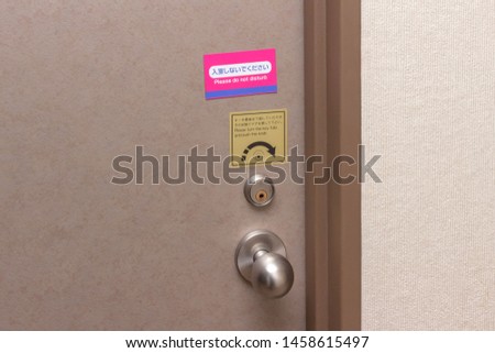 Door of hotel room with sign do not disturb(Japanese and English)
