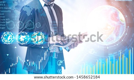 Businessman with laptop working with business infographics interface. Concept of stock market and hi tech. Toned image double exposure. Elements of this image furnished by NASA