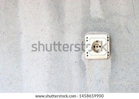 electrical outlet standing on old concrete wall