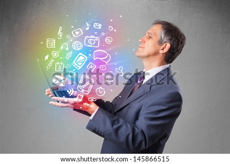 Middle aged businessman holding notebook with colorful hand drawn multimedia icons 