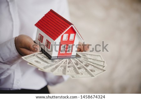 money and house in female hands, new house buy concept