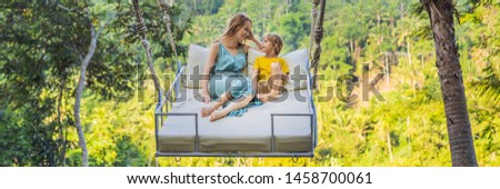 BANNER, LONG FORMAT Mother and son swinging in the jungle rainforest of Bali island, Indonesia. Swing in the tropics. Swings - trend of Bali. Traveling with kids concept. What to do with children