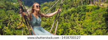 Young woman swinging in the jungle rainforest of Bali island, Indonesia. Swing in the tropics. Swings - trend of Bali BANNER, LONG FORMAT