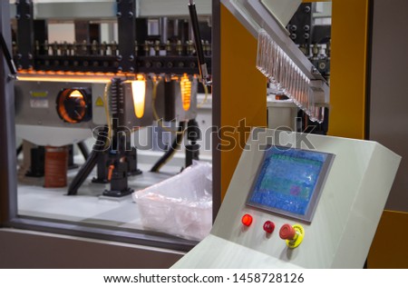 Raw material on conveyor to plastic bottle blow molding machine pre-heat process. Industrial machinery