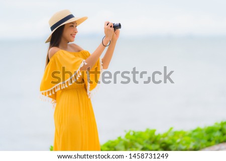 Portrait beautiful asian woman wear hat with smile happy leisure in take a photo on the beach and sea in holiday vacation concept