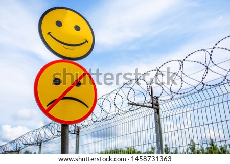 sign of the smiley face on a background of barbed wire